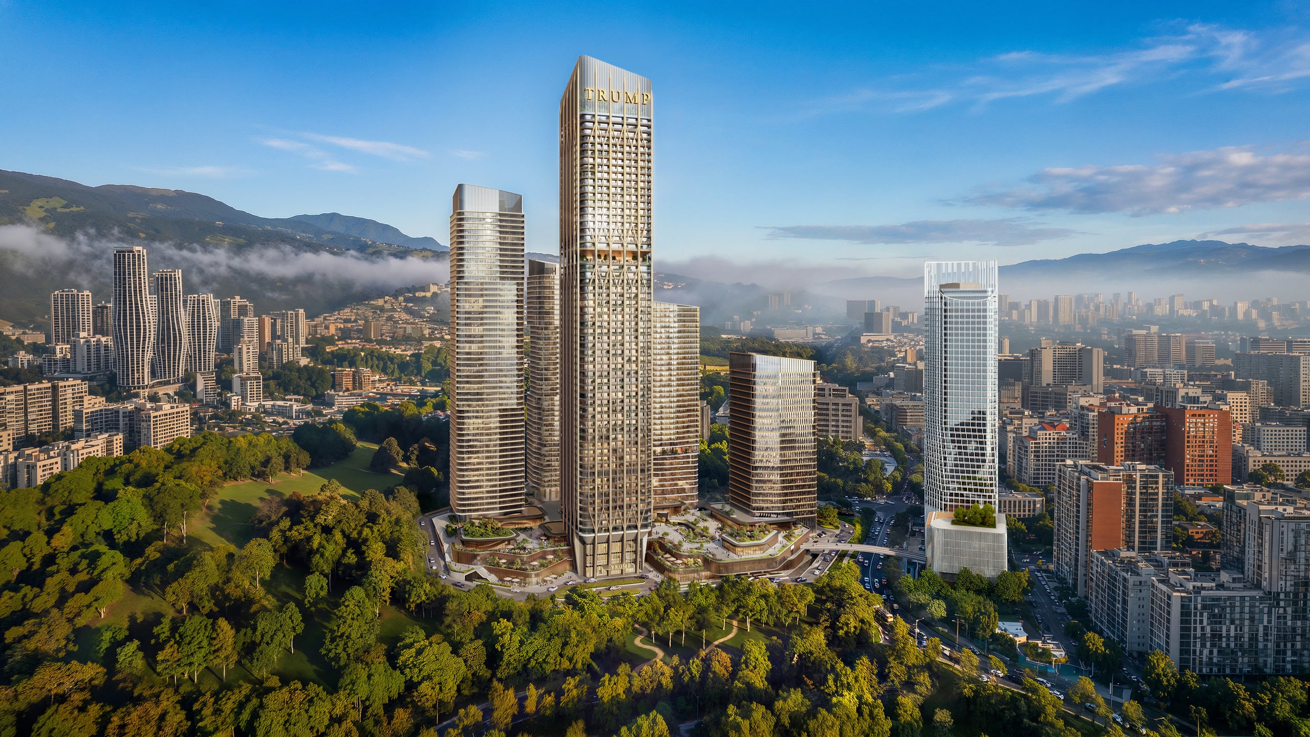 Trump Tower Tbilisi seen from Central Park in morning light, with the Caucasus foothills behind.