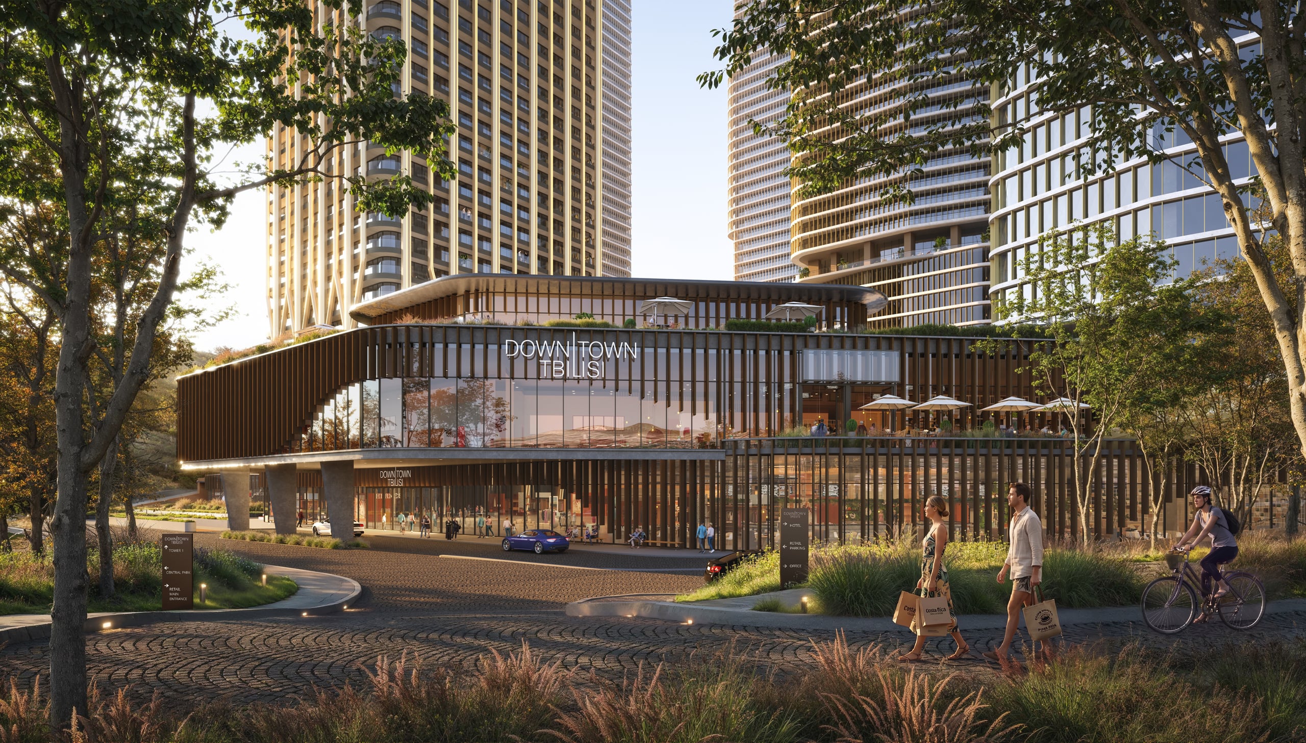The podium retail pavilion among mature trees, with the towers rising behind it.